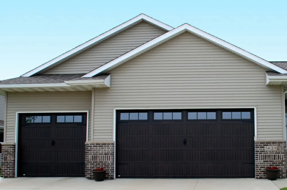 Dark carriage house style garage doors with window inserts