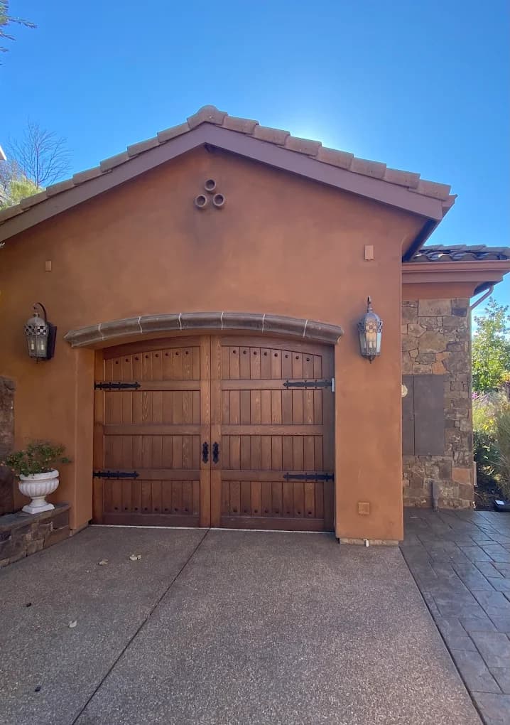 Custom wood carriage garage door with wrought iron hardware